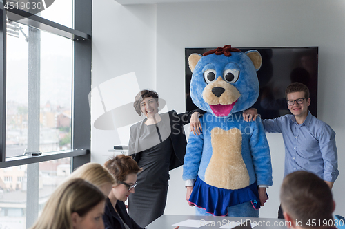 Image of boss dresed as bear having fun with business people in trendy of