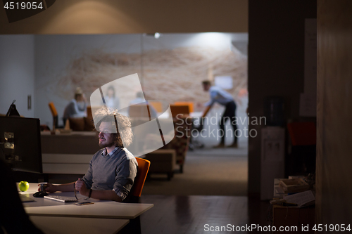 Image of man working on computer in dark office