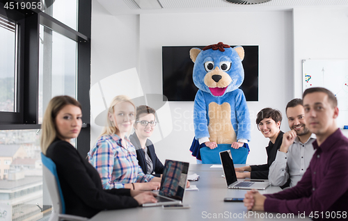 Image of boss dresed as bear having fun with business people in trendy of