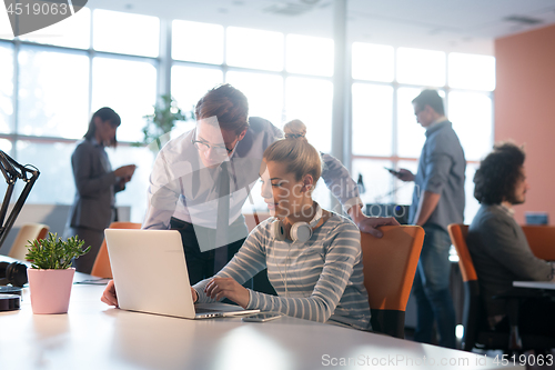 Image of Two Business People Working With laptop in office