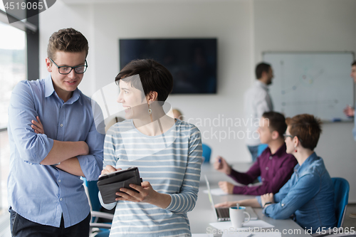 Image of Two Business People Working With Tablet in office
