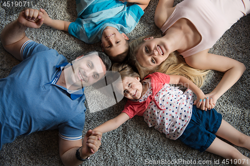 Image of happy family lying on the floor