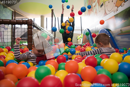 Image of Young mom with her kids in a children\'s playroom