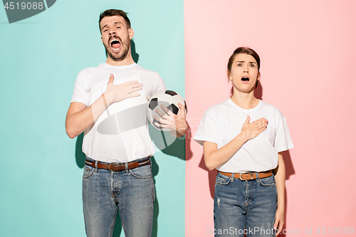 Image of The young fans singing national anthem on blue and pink trendy colors.