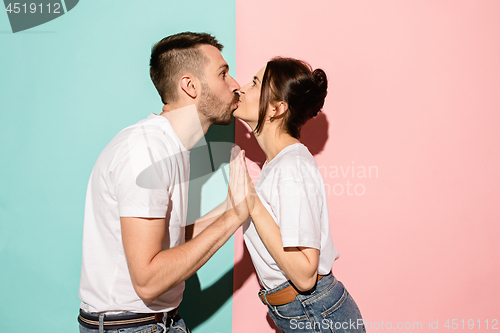 Image of A view of a loving couple kissing on blue and pink background