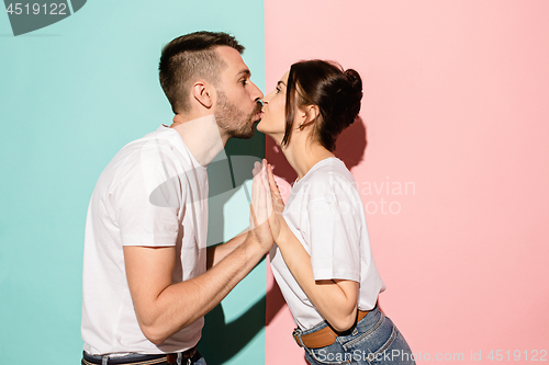 Image of A view of a loving couple kissing on blue and pink background