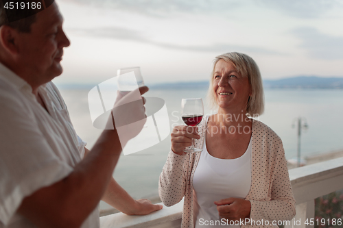 Image of A smiling middle aged couple on a terrace close to the sea