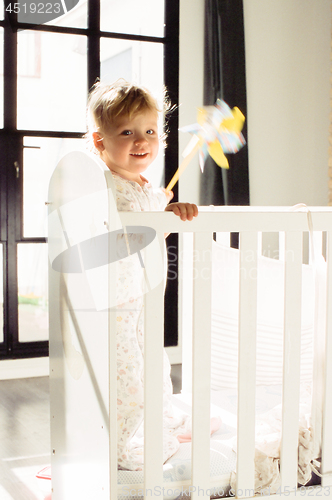 Image of Happy child with toy in the crib