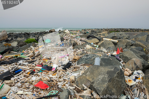 Image of Spilled garbage on the beach near the big city. Empty used dirty plastic bottles and other garbage. Environmental pollution. Ecological problem.
