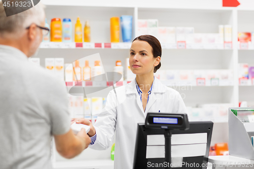 Image of apothecary selling drug to senior man at pharmacy