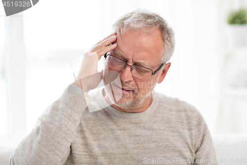 Image of senior man suffering from headache at home