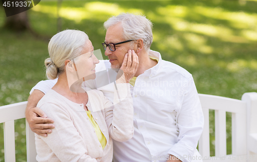 Image of happy senior couple sitting on bench at park