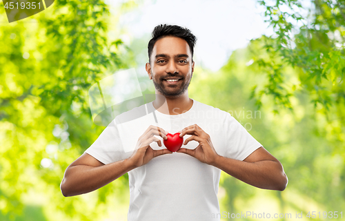 Image of indian man with red heart over natural background