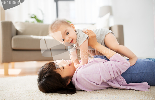 Image of happy young mother with little baby at home