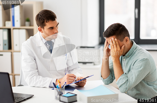 Image of doctor with clipboard and male patient at hospital