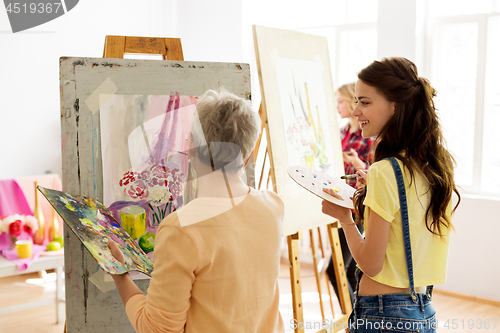 Image of happy women painting at art school studio