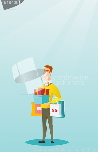 Image of Caucasian man holding shopping bags and gift boxes