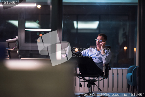 Image of businessman using mobile phone in dark office