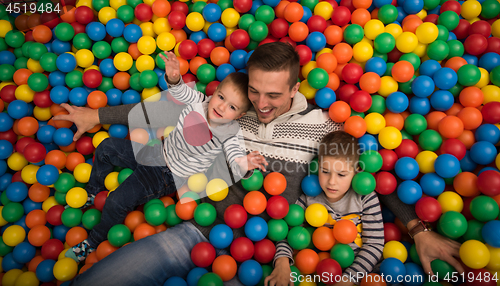 Image of Young dad with kids in a children\'s playroom