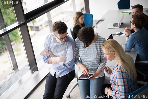 Image of group of Business People Working With Tablet in startup office