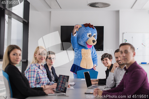 Image of boss dresed as bear having fun with business people in trendy of