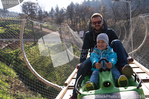 Image of father and son enjoys driving on alpine coaster