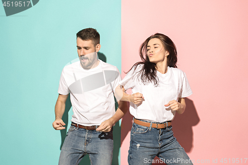 Image of A couple of young man and woman dancing hip-hop at studio.