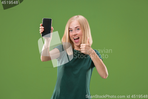 Image of Portrait of a confident casual girl showing blank screen mobile phone