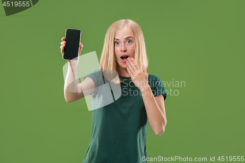 Image of Portrait of a confident casual girl showing blank screen mobile phone