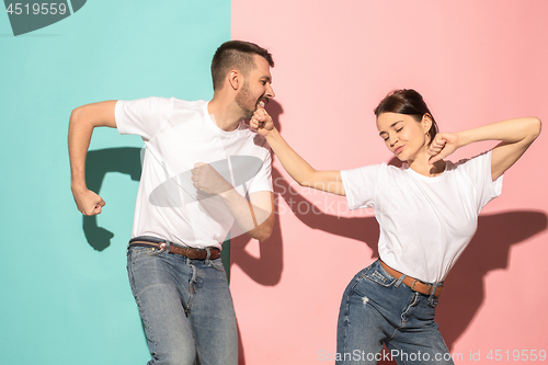 Image of A couple of young man and woman dancing hip-hop at studio.