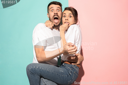 Image of Portrait of the scared man and woman on pink and blue