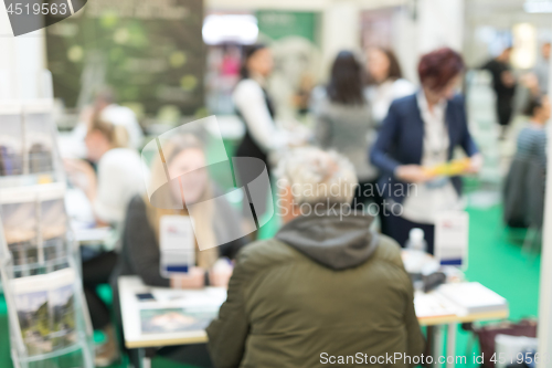 Image of Blured image of client consulting aobout product with saleswoman at business fair.