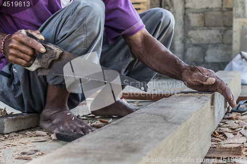 Image of Close up of warn hands of carpenter working in traditional manual carpentry shop in a third world country.