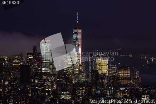 Image of New York City skyline with lower Manhattan skyscrapers in storm at night.