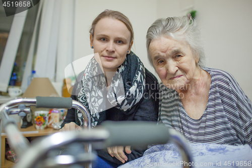 Image of A portrait of two women, young and elderly, sitting close to each other