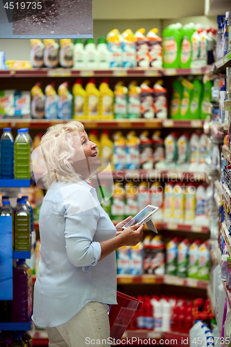Image of A smiling middle aged woman in a household section of a supermarket