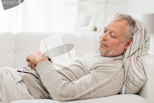 Image of senior man sleeping on sofa at home