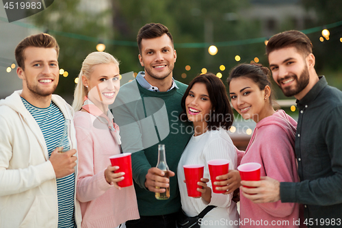 Image of friends with drinks in party cups at rooftop