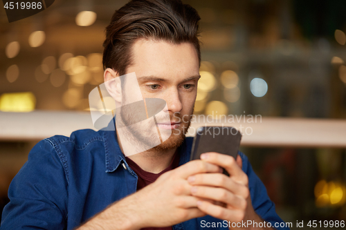 Image of close up of man with smartphone at restaurant