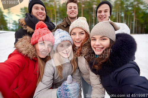 Image of group of friends taking selfie outdoors in winter