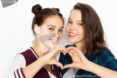 Image of happy smiling teenage girls showing heart sing