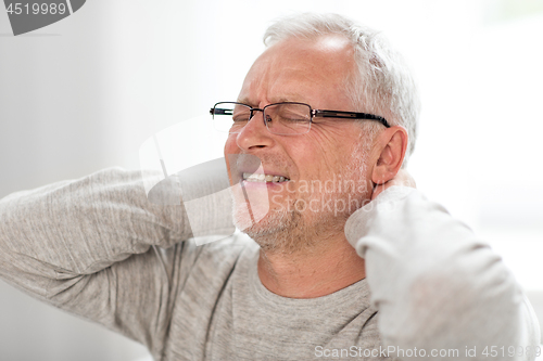 Image of senior man suffering from neckache at home