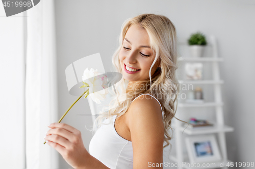 Image of woman in underwear with peony flower at window