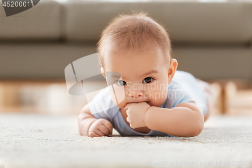 Image of sweet little asian baby boy lying on floor at home