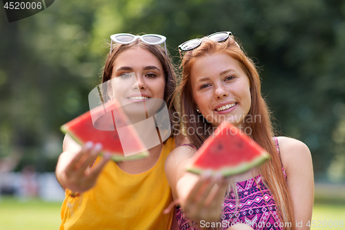 Image of teenage girls eating watermelon at picnic in park