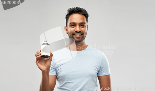 Image of indian man with medicine over grey background