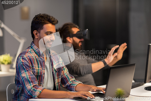 Image of creative man with laptop working at office