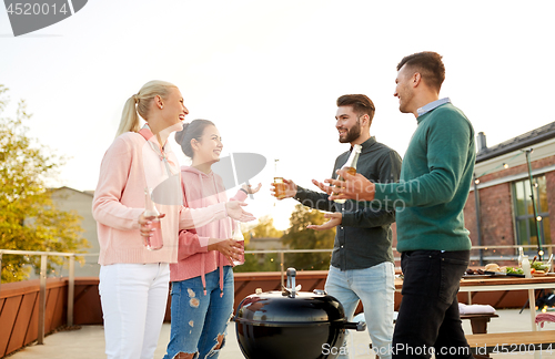 Image of happy friends having bbq party on rooftop