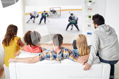 Image of friends watching ice hockey on projector screen