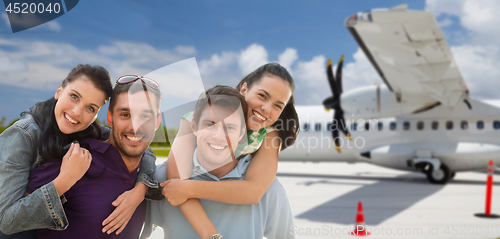 Image of happy friends over plane on airfield background